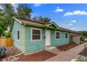 Charming single-story house boasts a vibrant green exterior, well-maintained landscaping, and a welcoming entrance at 999 Osceola St, Denver, CO 80204