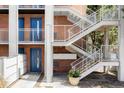 Brick apartment building exterior featuring blue doors, white railings, and staircase, providing a bright and modern look at 1 N Pearl St # 201, Denver, CO 80203