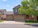 Two-story brick home featuring a tile roof and a two-car garage at 11842 Altura St, Commerce City, CO 80603