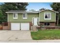 Home featuring solar panels, a charming entryway, and a well-maintained lawn at 11805 W 74Th Ave, Arvada, CO 80005