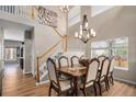 Stunning dining room featuring a large dining table, staircase, chandelier, and bright natural light at 9407 W Gibraltar Pl, Littleton, CO 80127