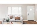 Cozy living room with plush sofa, accent pillows, and natural light from a large window at 2340 Jamaica St, Aurora, CO 80010