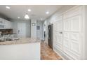 Well-lit kitchen features white cabinets, granite counters, and stainless steel refrigerator at 12281 E Tennessee Dr # 303, Aurora, CO 80012
