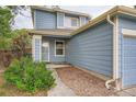 Close up of the front of the home with light blue siding and landscaping at 897 Mockingbird Ln, Brighton, CO 80601