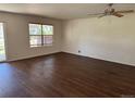 Spacious living room with hardwood floors, a ceiling fan, and a window providing ample natural light at 897 Mockingbird Ln, Brighton, CO 80601