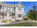 Charming gray townhome featuring a cozy front porch and lush green lawn at 1678 Wright Aly, Erie, CO 80516