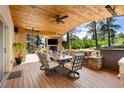 This covered patio offers dining and lounge areas with a fireplace and outdoor TV for relaxation at 17015 Oxbridge Rd, Monument, CO 80132