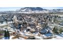 Aerial view of a residential area with houses covered in snow, mountain background at 17364 W 63Rd Dr, Arvada, CO 80403