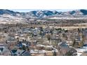 Aerial view of houses in a neighborhood during winter, with mountain backdrop at 17364 W 63Rd Dr, Arvada, CO 80403