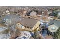 Aerial view of a house with backyard patio, surrounded by other homes in a snowy neighborhood at 17364 W 63Rd Dr, Arvada, CO 80403