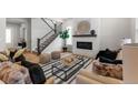 Open-concept living room with modern fireplace and view of the staircase at 890 Coal Bank Trl, Castle Rock, CO 80104