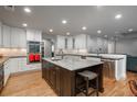 Bright, spacious kitchen featuring a large island, white cabinets, stainless steel appliances, and hardwood floors at 5164 E Princeton Ave, Cherry Hills Village, CO 80113
