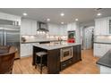 Modern kitchen features white cabinets, stainless steel appliances, and a central island with a built-in microwave at 5164 E Princeton Ave, Cherry Hills Village, CO 80113