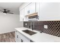 Modern kitchen boasts white cabinets, black hardware, and hexagon tile at 50 E Highline Cir # 102, Centennial, CO 80122