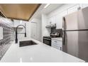 Modern kitchen with white cabinets, stainless steel appliances, and hexagon tile backsplash at 50 E Highline Cir # 102, Centennial, CO 80122