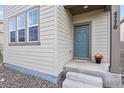 Welcoming front entryway with stylish blue door and decorative pot with flowers at 4770 N Jasper St, Denver, CO 80239