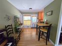 Bright dining area featuring wood floors, a high-top table with stools, and an adjacent kitchen at 1245 S Forest St, Denver, CO 80246