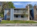 Two-story condo with blue siding and stone accents, featuring a private balcony and reserved parking space at 8600 E Alameda Ave # 17-105, Denver, CO 80247