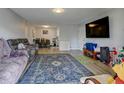 Cozy living room with hardwood floors, a large sofa, and a view into the dining area and kitchen at 8600 E Alameda Ave # 17-105, Denver, CO 80247