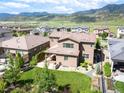 Aerial view of a two-story house with a lush backyard, patio area, and views of the surrounding landscape at 2130 S Poppy St, Lakewood, CO 80228