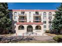 Facade of condo building featuring brickwork, balconies, a central entrance, and meticulous landscaping for a welcoming appeal at 7801 W 35Th Ave # 405, Wheat Ridge, CO 80033