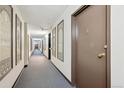 Hallway with neutral carpet and paint, decorative framed art, and doors leading to individual units at 7801 W 35Th Ave # 405, Wheat Ridge, CO 80033