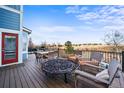 Back deck with seating around a fire pit, overlooking an open field with a clear blue sky at 21093 E Hampden Pl, Aurora, CO 80013