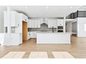 New kitchen featuring white cabinets, a large center island, and modern appliances at 3340 Backdrop Ct, Castle Rock, CO 80108