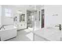 Bright, luxury bathroom featuring double vanity, soaking tub, and glass-enclosed shower at 3340 Backdrop Ct, Castle Rock, CO 80108