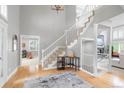 Bright foyer with hardwood floors, an elegant staircase, and an open view into the living spaces at 920 Shady Oak Ln, Castle Pines, CO 80108