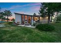 Landscaped modern home exterior with stone accents, patio, and lush green lawn at 8045 Eagle Rd, Larkspur, CO 80118