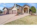 Elegant stucco home with stone detailing, a three-car garage, manicured landscaping, and a welcoming entrance at 4337 W Hinsdale Ave, Littleton, CO 80128