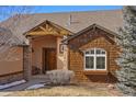 Inviting front entry with a wood door and stone pillars, creating a warm and welcoming ambiance at 3441 Medallion Rd, Castle Rock, CO 80104