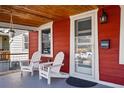 Cozy front porch featuring two chairs, a hanging plant, and a decorative exterior light fixture at 4452 Zenobia St, Denver, CO 80212
