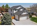 Aerial view of a two-story home featuring a brick facade, two car garage, and fenced in back yard at 13972 Hudson Way, Thornton, CO 80602