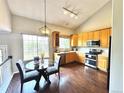 Eat-in kitchen with stainless steel appliances, wood cabinets, and modern lighting at 18997 E Crestridge Cir, Aurora, CO 80015