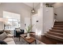 Open-concept living room with hardwood floors, high ceilings, and staircase at 18997 E Crestridge Cir, Aurora, CO 80015