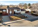 Exterior elevation of a split level house with a brick facade, garage and well-maintained yard at 11423 Steele St, Thornton, CO 80233