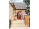 Inviting front porch with a bright red door, brick detailing and a cozy seating area at 983 S Josephine St, Denver, CO 80209