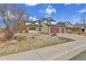 Beautiful two-story home with a three-car garage and front yard with mature tree at 5885 Kingsfield St, Castle Rock, CO 80104