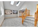 Bright foyer featuring skylights, tile flooring, and a staircase with wood railings at 5885 Kingsfield St, Castle Rock, CO 80104