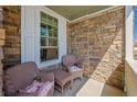 Relaxing front porch with stone accents and cozy seating area, perfect for enjoying the outdoors at 12728 Jasmine St # E, Thornton, CO 80602