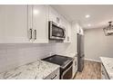 Contemporary kitchen design with white cabinets, subway tile backsplash, and updated appliances at 7455 E Quincy Ave # 103, Denver, CO 80237