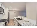 Bright kitchen boasts modern white cabinets, granite countertops, and stainless steel appliances at 7455 E Quincy Ave # 103, Denver, CO 80237