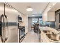 Well-lit kitchen with stainless steel appliances, granite countertops, and a pass-through to the dining area at 8100 W Quincy Ave # 11, Denver, CO 80123