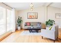 Sunlit living room with wood floors, modern decor, and stylish furnishings at 11647 E Wesley Ave, Aurora, CO 80014
