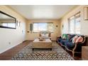 Bright living room with hardwood floors, a large window, and designer rug with stylish furniture at 3559 Hudson St, Denver, CO 80207