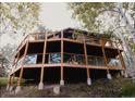 Rustic home featuring a large, multi-level wooden deck with glass and cable railings, perched on a hillside among mature trees at 20033 Silver Ranch Rd, Conifer, CO 80433