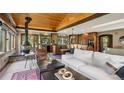 Inviting living room featuring wood beam ceilings, a cozy fireplace, and an open floor plan with view to the backyard at 20033 Silver Ranch Rd, Conifer, CO 80433