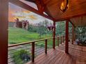 Charming wood porch with cable railings, hanging baskets, and sunset views at 20033 Silver Ranch Rd, Conifer, CO 80433